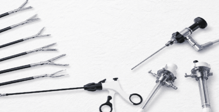 Advanced laparoscopic surgical instruments and trocars arranged on a textured white background for minimally invasive surgery procedures