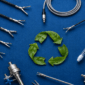 Reusable laparoscopic surgical instruments and trocars arranged around a green leaf recycle symbol on a blue textured background
